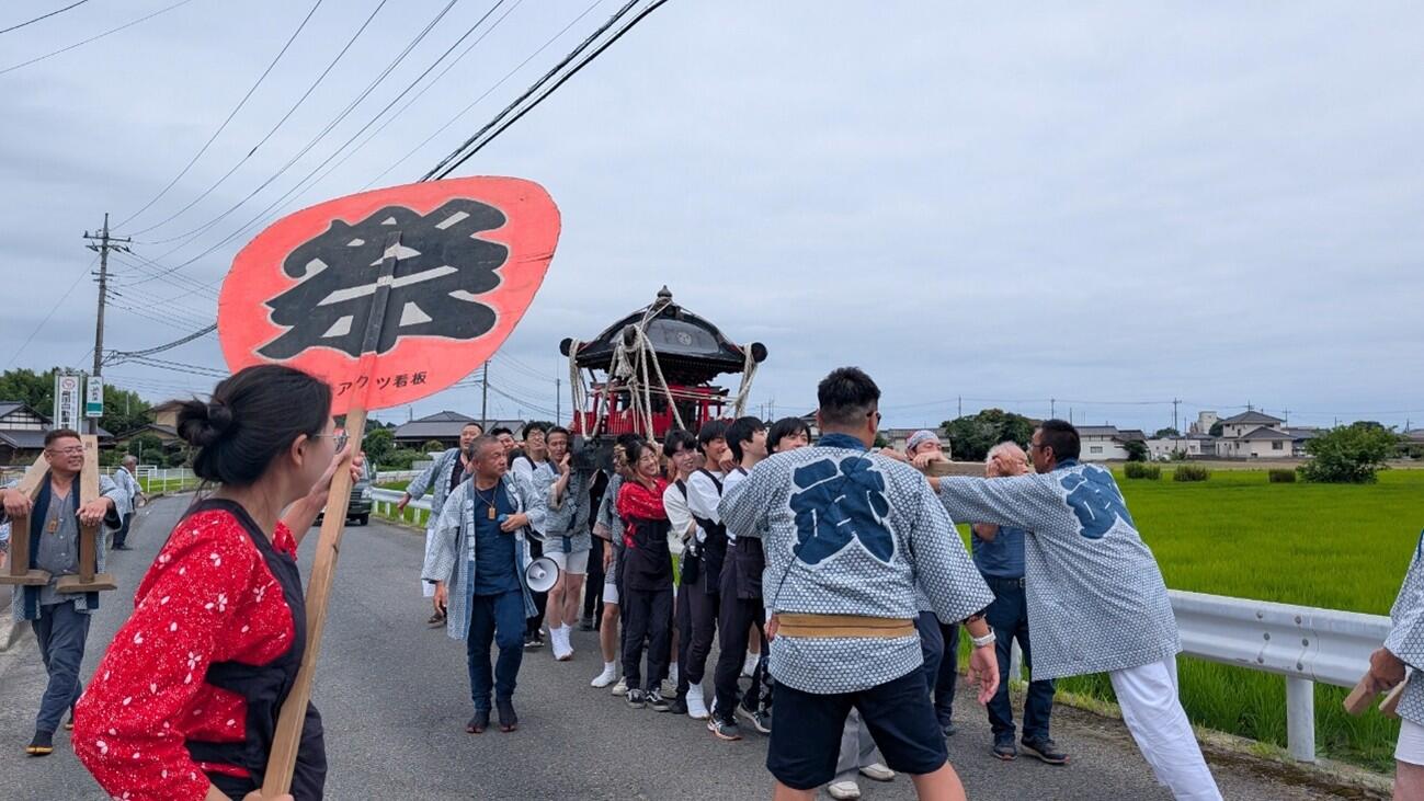 公民館から漬物店まで神輿をかつぐ参加者