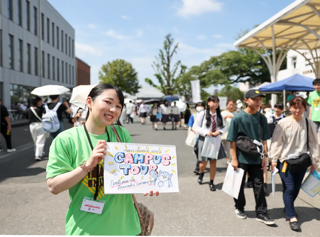 オープンキャンパスの看板を持った茨大生